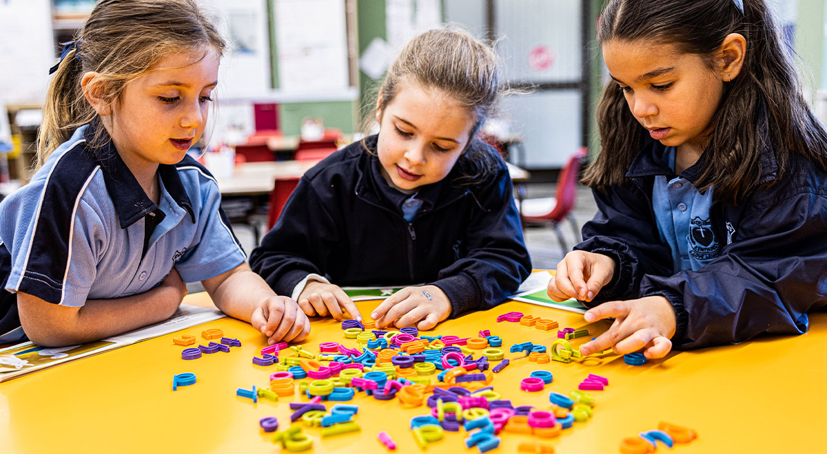 Students play with magnetic letters at St Madeleine's Catholic Primary School Kenthurst