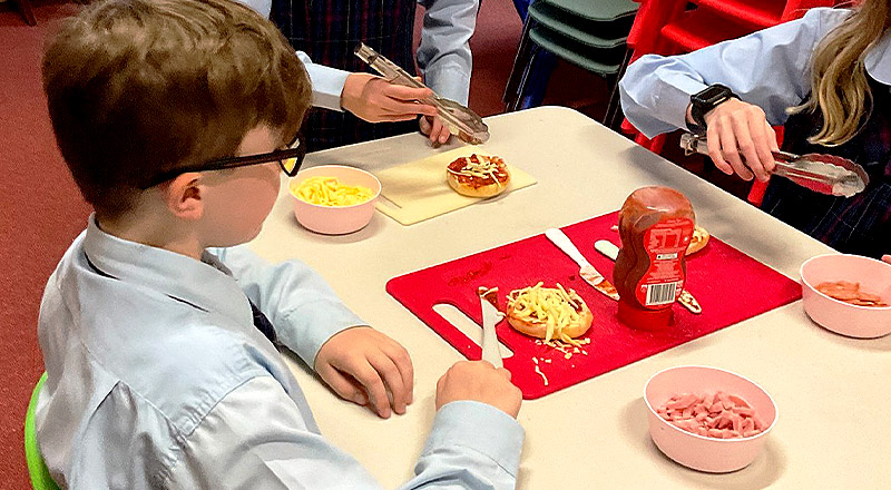 Student making pizza at Ambrose at St Madeleine's Catholic Primary School Kenthurst