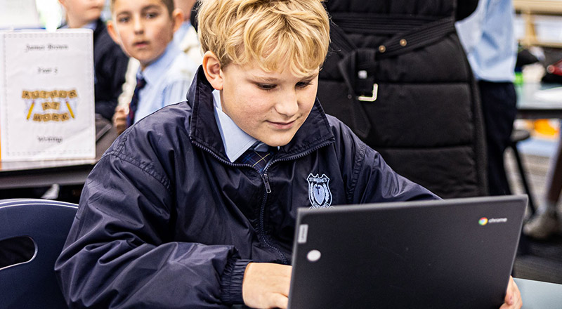 Boy on laptop learning at St Madeleine's Catholic Primary School Kenthurst