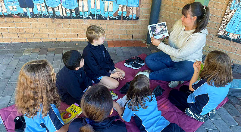 Parent reading to students at St Madeleine's Catholic Primary School Kenthurst