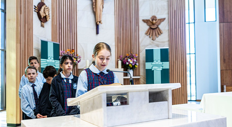 Students speaking at lectern at St Madeleine's Catholic Primary School Kenthurst